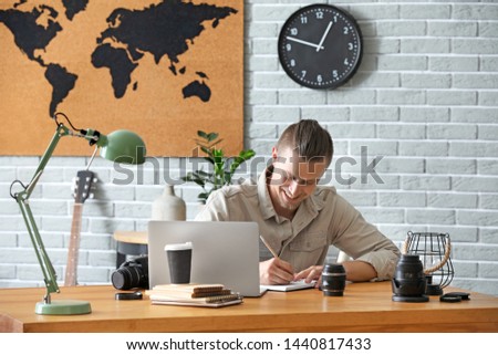 Male blogger with laptop at table