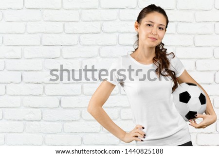 Soccer fan. Young beautiful woman holding soccer ball over isolated background
