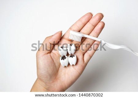 Hand Hold Decayed Tooth with White Toothbrush. Check and Take Care Your Tooth.
