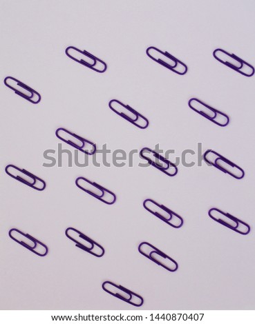 lots of purple paper clips on lilac paper