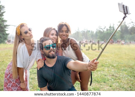 Group of friends taking a selfie using stick