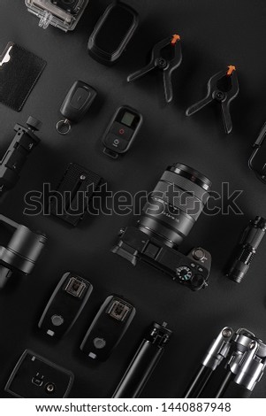 Work space videographer with laptop, digital camera, memory card, action camera, drone, remote controller, phone and camera accessory. Top view on black table background. Concept of mockup template.