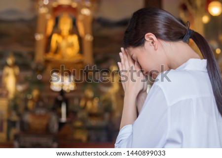 Pious, religious Asian buddhist woman praying, chanting mantra to the lord Buddha; Buddhist religion concept Royalty-Free Stock Photo #1440899033