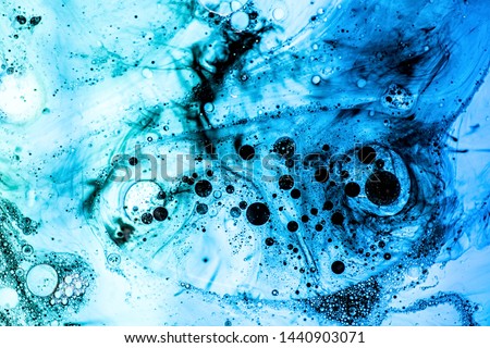 Abstract background. Bright blue bubbles with black ink on water surface