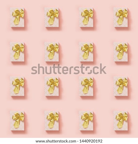 Gift boxes in pink paper with golden ribbon on pastel pink surface. Top view. Seamless pattern. Flat lay design template. Celebration anniversary background.