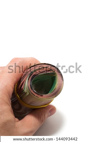 Hand holding a roll of bank notes with yellow plastic band