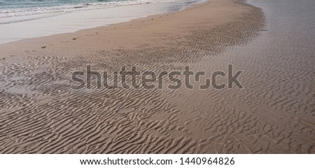 The sand is a wave with a single footprint. By the sea in the evening