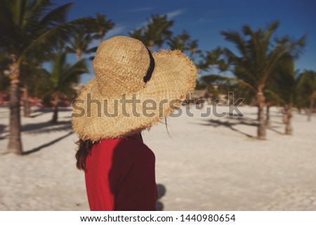 woman in a big hat is resting on the beach                               