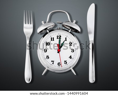 Alarm clock with knife and fork  for mealtime or diet concept