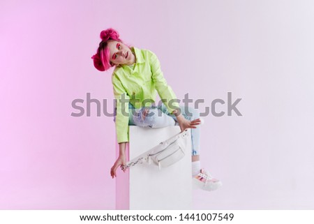 woman in a green jacket sits on a chair