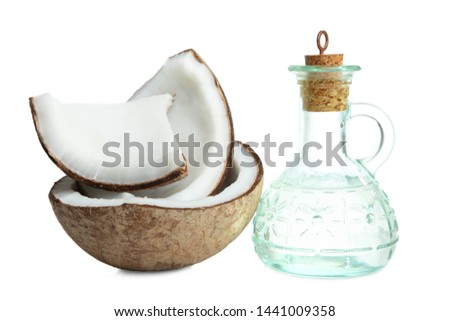 Broken exotic coconut and glass bottle with coconut oil isolated on white. Concept beauty, health.