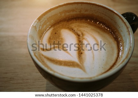 Leftover coffee in black cup on wood table background. - Image