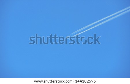 airplane with jet trace against blue sky