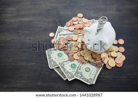 piggy bank with money on dark wooden background