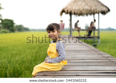 Portrait of Smilling Thai child sitting on the bridge feeling happiness