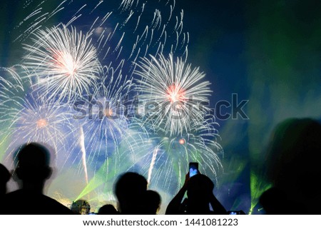 Crowd watching fireworks and celebrating city founded. Beautiful colorful fireworks display in the urban for celebration on dark night background.