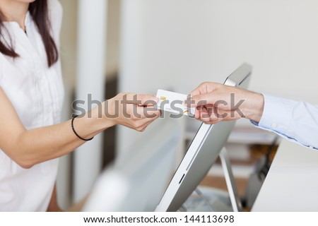 Closeup of receptionist receiving card from male patient in dentist clinic Royalty-Free Stock Photo #144113698
