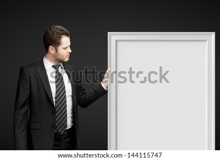 businessman holding frame on a black background