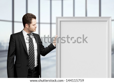 businessman holding blank frame in office