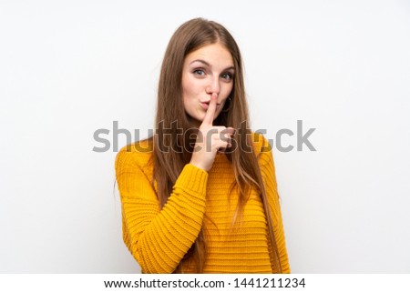 Young woman with yellow over isolated white wall doing silence gesture