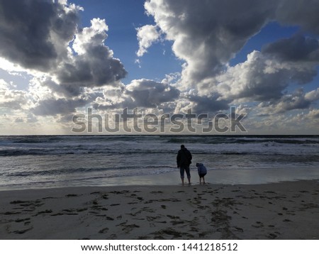 father and son walking by the sea