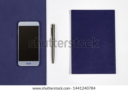 Work space  concept. Top view on desk with smartphone, notebook, pen above white background. Office desk. Copy space. 
