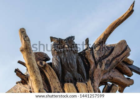 carved figure of an owl sitting on a tree
