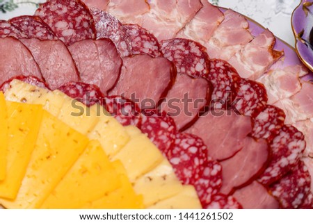Sausage and cheese sliced on a plate. Selective focus