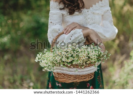 Girl with a basket of daisies with blur