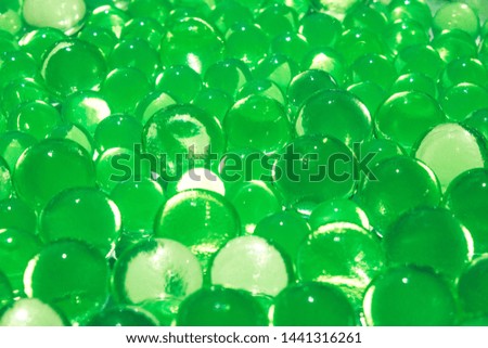 Bright green lime color abstract background of gel balls. Macro of hydrogel polymer. Herbal juicy wallpaper. Spring fresh texture for designers
