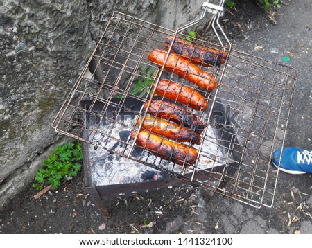B-B-Q. Sausage grill on a cloudy rainy day. Sausages on the grill. Grill food, barbecue, barbecue