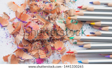 Wooden pencil shavings and colorful crumbs of graphite from sharpener. Abstract image: urgency and importance concept.