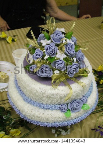 Wedding anniversary cake decorated with white and blue icing in a floral design.