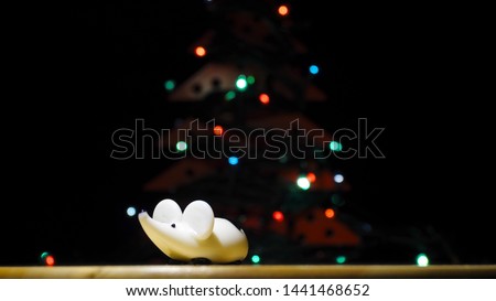Christmas white rat under the tree. Christmas tree shines with colored lights. Year of the rat or mouse