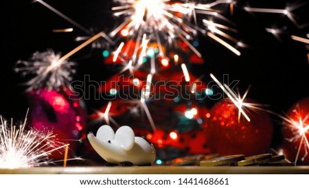 Christmas photo of a white mouse on the background of lights and salute. New Year card