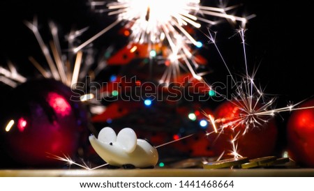 Christmas rat and bright festive fireworks. Christmas tree shines with colored lights. Year of the rat or mouse