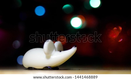 New Year's white rat. Christmas rat on the background of blurry lights and shooting fireworks. Christmas Rat