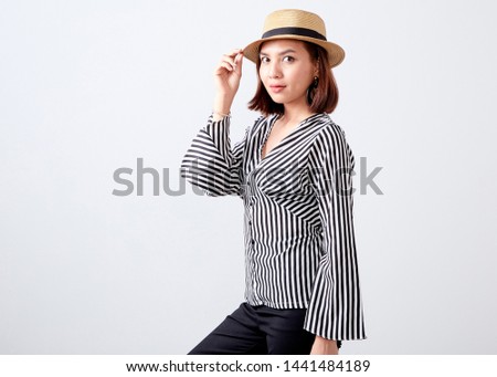 Closeup fashion studio portrait of asian young woman business smiling with hat white wall background