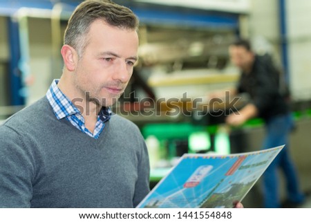 printer checking a print run at table