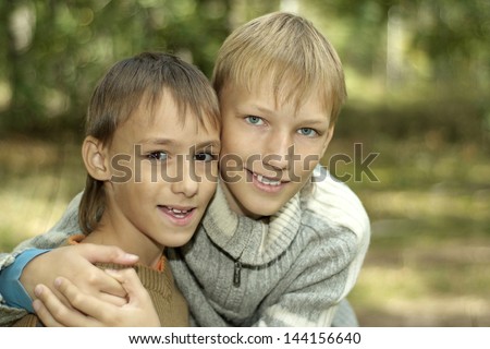 two young boys walking in the forest in autumn