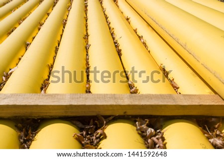 Natural gas pipes and gas pipelines are stacked at a construction site covered with fallen leaves