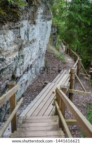 Tourist trail with wooden pathwalk and stairs near sandstone cliffs. The cliff of Sietiniezis, Latvia. Gauja National Park.