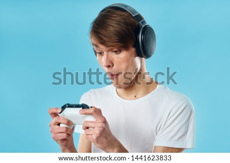 Cute guy in headphones with a joystick in the hands of a lifestyle game console fun technology