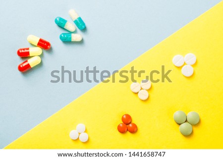 Colorful vitamin pills, capsules and medicine ampoules on an abstract background. Healthcare, medical and pharmaceutical flatlay concept. Detailed close up studio shot with copy space. Toned