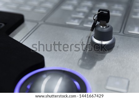 Industrial control panel made of gray metal with blue trackball, keyboard and security lock key, close up photo with soft selective focus Royalty-Free Stock Photo #1441667429
