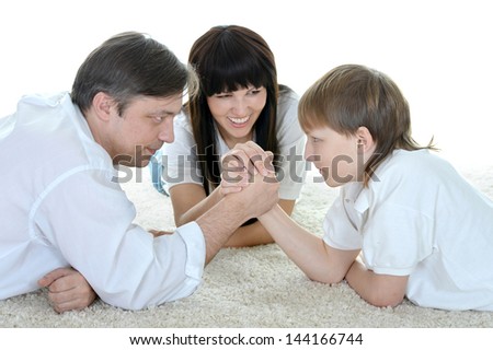 cheerful family in white shirts resting on the floor at home