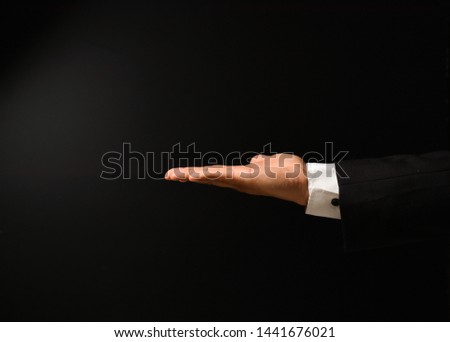 Businessman's hand on black background to add text with expressions and cards