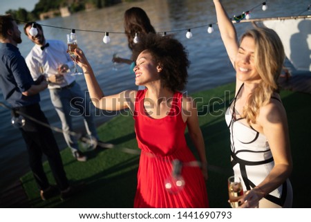 Group of happy people or friends having fun at party