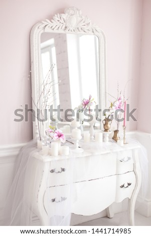 Royal bedroom. Place for make-up girls. Elegant white dressing table with mirror in light classic luxury interior.