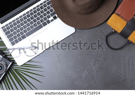 Flat lay composition with laptop and travel blogger's stuff on stone surface, space for text